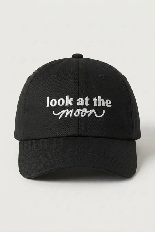 Black cap with 'look at the moon' text on a white background