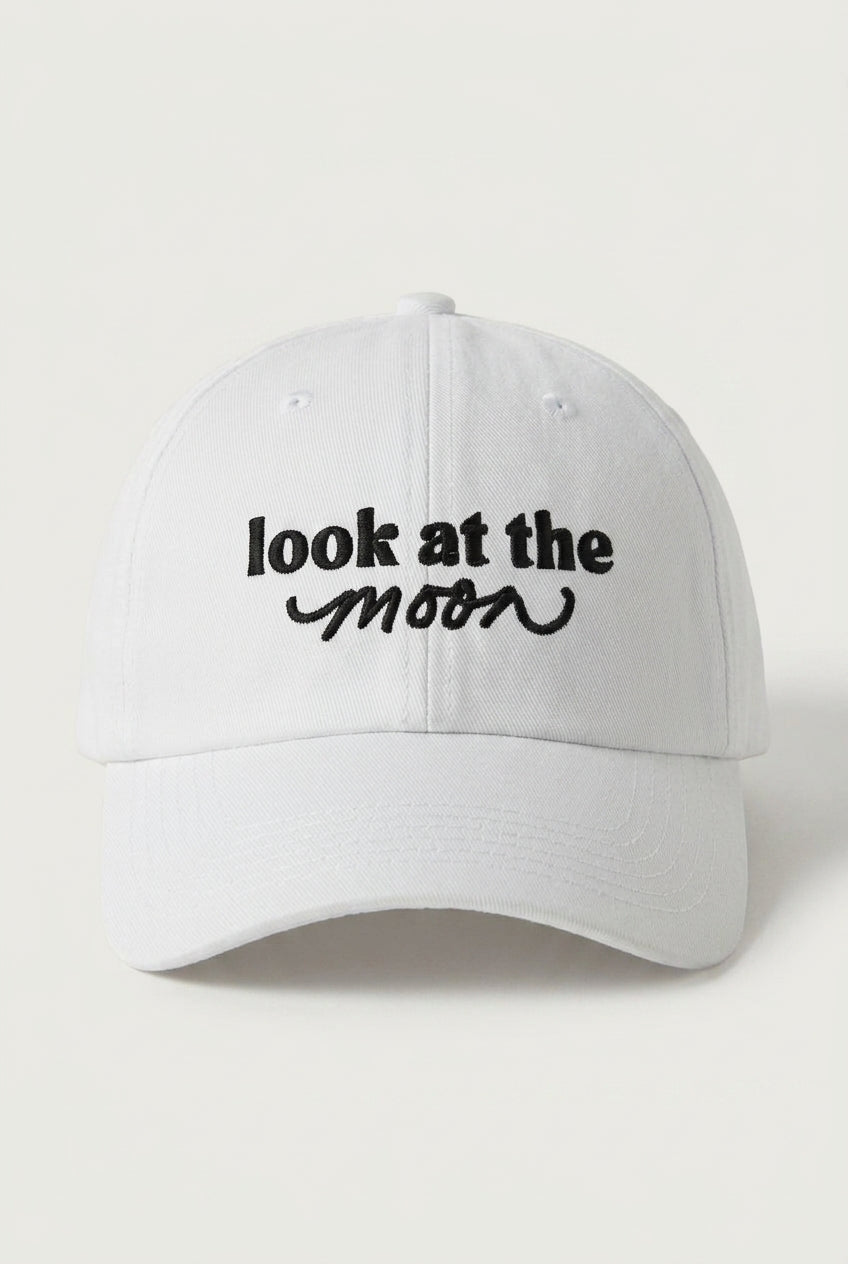 White cap with 'look at the moon' text on a light gray background