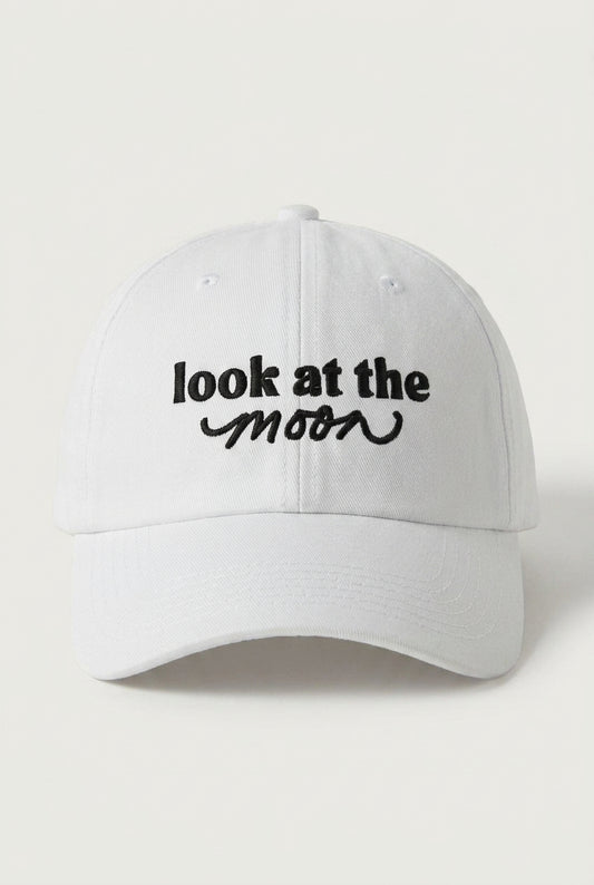 White cap with 'look at the moon' text on a light gray background